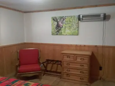 a bedroom with a red chair and a dresser at Colorado Cabin Adventure in Grand Lake