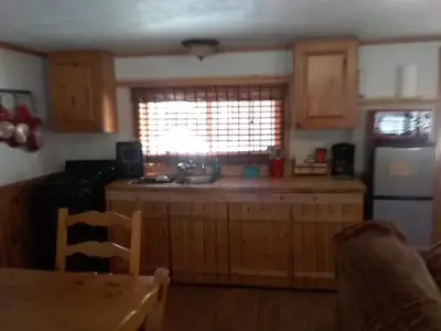 a kitchen with wooden cabinets and a sink and a window at Colorado Cabin Adventure in Grand Lake