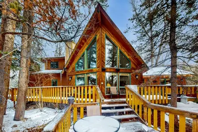a log cabin in the woods in the snow at Blue Riverfront Retreat in Silverthorne