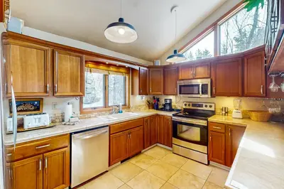 a kitchen with wooden cabinets and stainless steel appliances at Blue Riverfront Retreat in Silverthorne