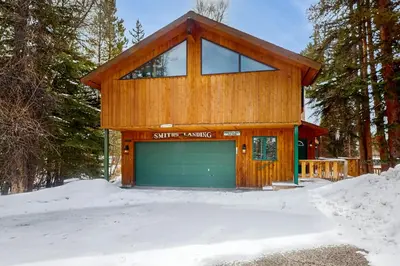 a house with a garage in the snow at Blue Riverfront Retreat in Silverthorne