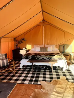 a bedroom with a bed in a tent at Colorado Getaways in this Lovely Safari Tent on Working Sheep Farm in Longmont in Longmont