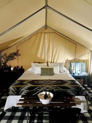 a bed in a tent with a bowl on it at Colorado Getaways in this Lovely Safari Tent on Working Sheep Farm in Longmont in Longmont
