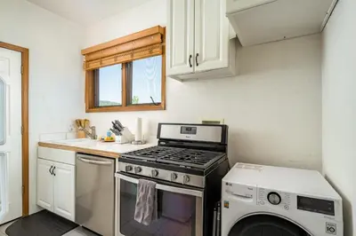 a kitchen with a stove and a washing machine at 5 Bedroom Whole Home with Mountain Views in Evergreen
