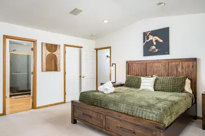 a bedroom with a bed with a wooden headboard at 5 Bedroom Whole Home with Mountain Views in Evergreen