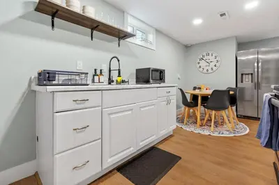 a kitchen with white cabinets and a table with chairs at 5Bed, 2Bath, 2 Kitchens, Home Office, Pet-Friendly in Denver