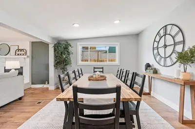 a dining room with a table and chairs and a clock at 5Bed, 2Bath, 2 Kitchens, Home Office, Pet-Friendly in Denver