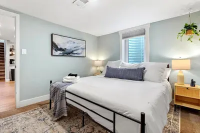 a bedroom with a large white bed and a window at 5Bed, 2Bath, 2 Kitchens, Home Office, Pet-Friendly in Denver