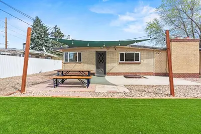 a wooden picnic table in front of a house at 5Bed, 2Bath, 2 Kitchens, Home Office, Pet-Friendly in Denver
