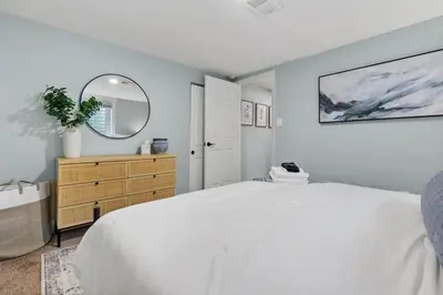 a bedroom with a large white bed and a mirror at 5Bed, 2Bath, 2 Kitchens, Home Office, Pet-Friendly in Denver
