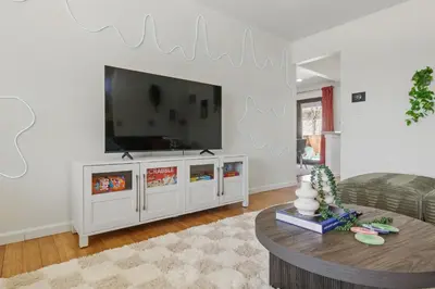 a living room with a large flat screen tv on a wall at Spacious 4BD - Backyard BBQ, Fire Pit & Mini Golf in Arvada