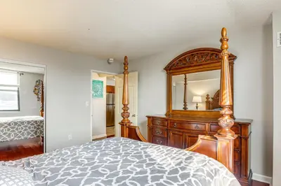 a bedroom with a wooden dresser and a large mirror at Less Than 1 Mi to Downtown Denver Condo with Pool Access! in Denver