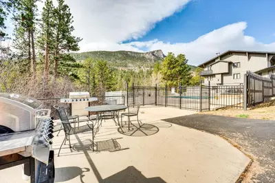 a patio with a table and chairs and a grill at 1 Mi to Rocky Mtn Natl Park Estes Park Townhome in Estes Park