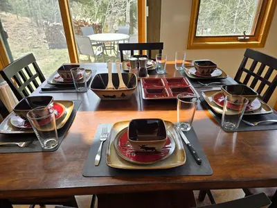 a wooden table with plates and utensils on it at Moose Manor in Golden