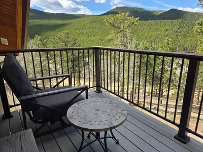 a chair and a table on a porch with a view at Moose Manor in Golden