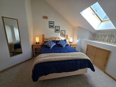 a bedroom with a bed with blue pillows and a window at Moose Manor in Golden