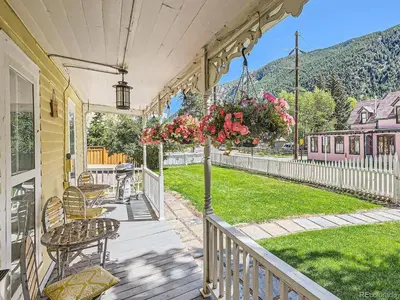 a porch with chairs and a table with flowers at Historic 4 bedroom Victorian Home in Downtown Georgetown in Georgetown