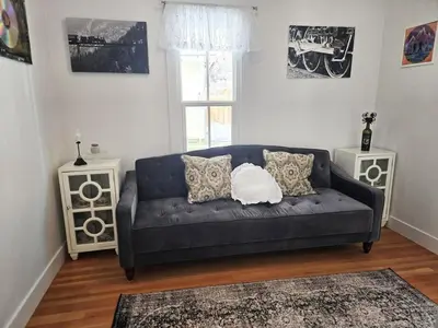 a living room with a black couch and two tables at Victorian Dream! Charming Mountain View Home by Downtown in Georgetown