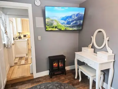 a room with a vanity and a fireplace with a television on the wall at Victorian Dream! Charming Mountain View Home by Downtown in Georgetown