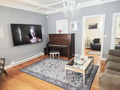 a living room with a piano and a table at Victorian Dream! Charming Mountain View Home by Downtown in Georgetown