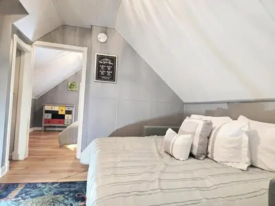 a bedroom with a large bed with white pillows at Charming Downtown Apartment in Victorian Home with Mountain Views in Georgetown
