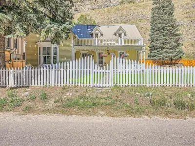 a white picket fence in front of a house at Charming Downtown Apartment in Victorian Home with Mountain Views in Georgetown