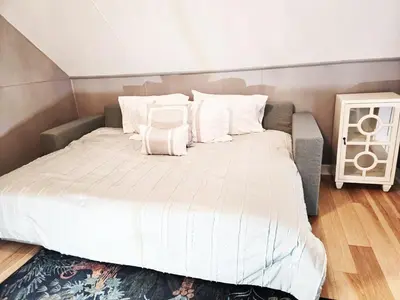 a bedroom with a large bed with white sheets and pillows at Charming Downtown Apartment in Victorian Home with Mountain Views in Georgetown