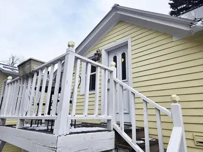 a house with a white railing on a porch at Charming Downtown Apartment in Victorian Home with Mountain Views in Georgetown