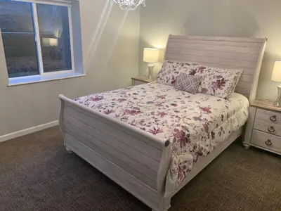 a bedroom with a bed with a floral bedspread and a window at Cozy Home and Tidy Monthly Weekly Deals in Arvada