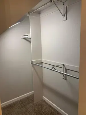 an empty closet with a white wall and glass shelves at Cozy Home and Tidy Monthly Weekly Deals in Arvada
