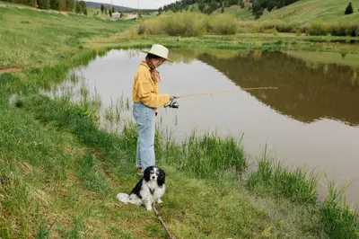 a man with a dog hooked up to a fishing rod at Colorado Glamping Adventures in Golden Gate Canyon Park, in this Cute Cabin Rental in Black Hawk