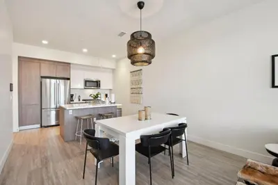 a kitchen and dining room with a white table and chairs at 2880(U306): Sunlit Escape in Denver