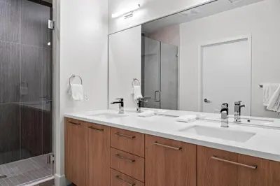 a bathroom with two sinks and a large mirror at Mile High Muse Lifestyle Loft Espadin LoHi in Denver