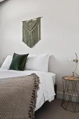 a bedroom with a bed with white sheets and green pillows at Mile High Muse Lifestyle Loft Espadin LoHi in Denver