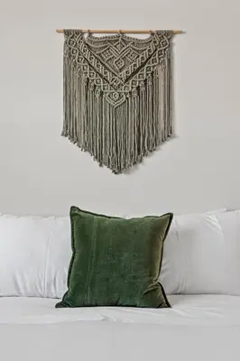 a blanket hanging over a bed with a green pillow at Mile High Muse Lifestyle Loft Espadin LoHi in Denver
