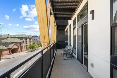 a balcony with two chairs on a building at Mile High Muse Lifestyle Loft Espadin LoHi in Denver