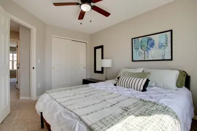 a bedroom with a large bed with a ceiling fan at La Casita with Private Yard 17 Mi to Dtwn Denver in Henderson