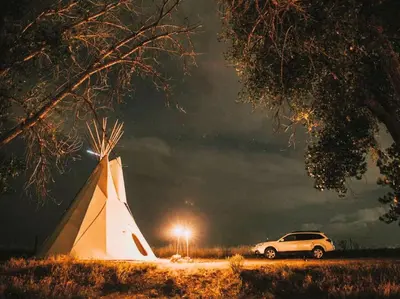 a car parked next to a tent at night at Cozy and Authentic Tipi Rental on Working Horse Ranch near Denver, Colorado in Hudson