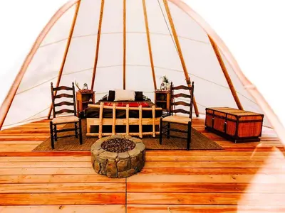 a room in a dome tent with a bed and two chairs at Cozy and Authentic Tipi Rental on Working Horse Ranch near Denver, Colorado in Hudson