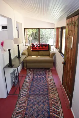 a living room with a couch and a rug at Romantic Hideaway Cottage on Clear Creek in Georgetown, Colorado in Georgetown