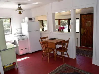 a kitchen with a table and chairs and a refrigerator at Romantic Hideaway Cottage on Clear Creek in Georgetown, Colorado in Georgetown