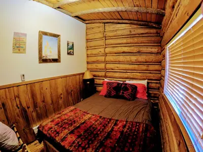 a bedroom with a bed in a log cabin at Arrowhead in Grand Lake