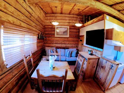 a dining room with a table in a log cabin at Arrowhead in Grand Lake