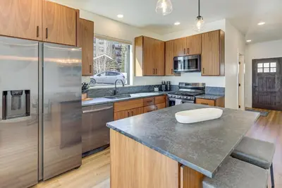 a kitchen with wooden cabinets and a stainless steel refrigerator at Walk to Ski Lift Granby Ranch Family Retreat! in Granby