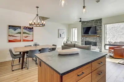 a kitchen and living room with a table and a fireplace at Walk to Ski Lift Granby Ranch Family Retreat! in Granby