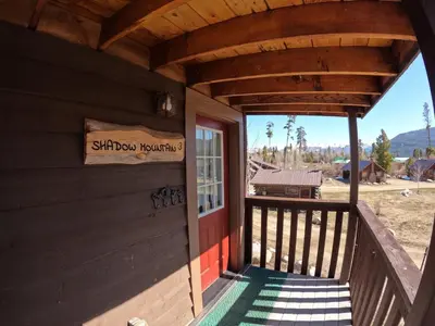 a porch of a log cabin with a sign on it at Shadow Mountain in Grand Lake