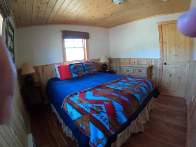 a bedroom with a bed with a blue comforter at Shadow Mountain in Grand Lake