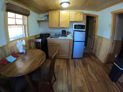 a kitchen with a wooden table and a wooden floor at Shadow Mountain in Grand Lake