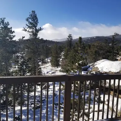 a view of a snow covered mountain from a deck at Cabin in the Woods in Red Feather Lakes