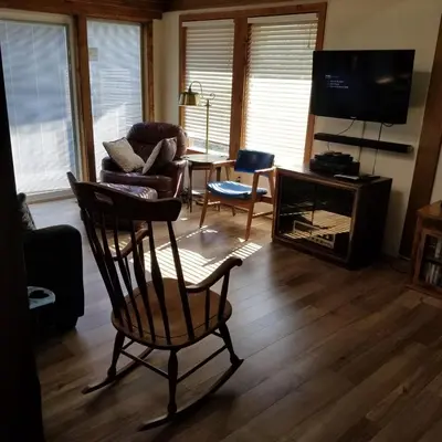 a living room with a chair and a television at Cabin in the Woods in Red Feather Lakes